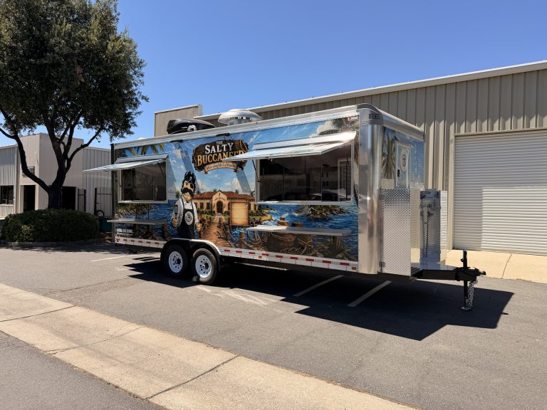 The Salty Buccaneer 22-ft school food trailer with two open concession windows and nautical wrap