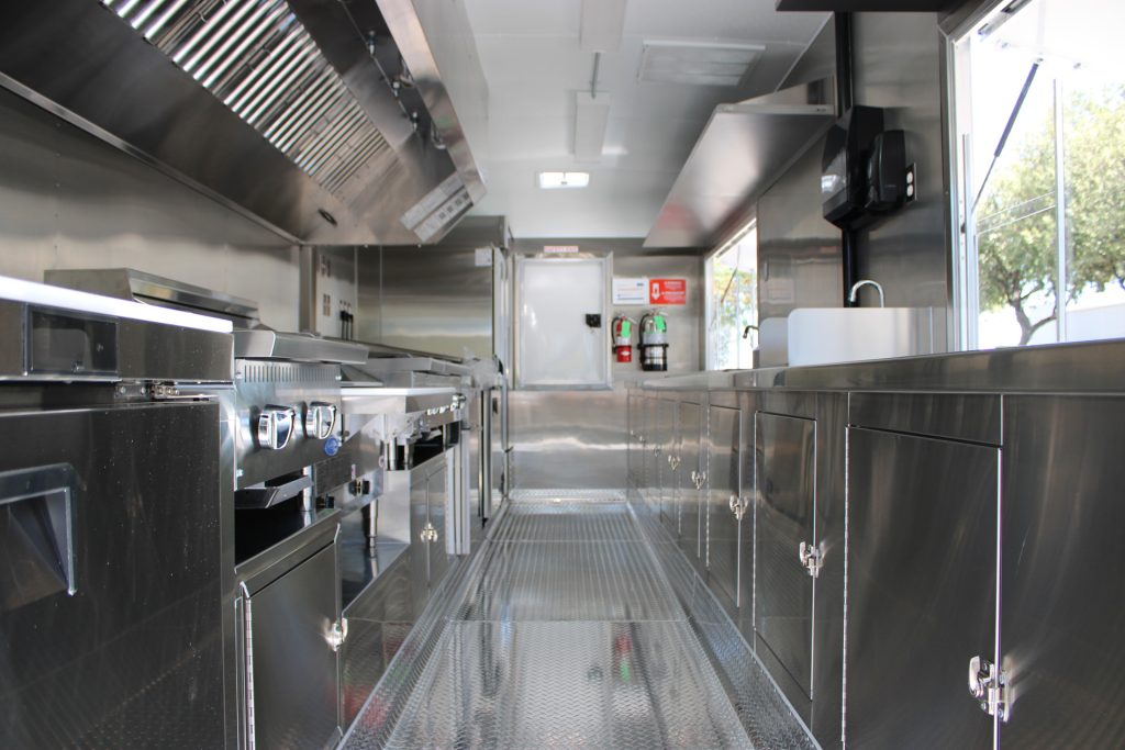 Interior of 22-ft school food trailer with stainless steel kitchen and central aisle