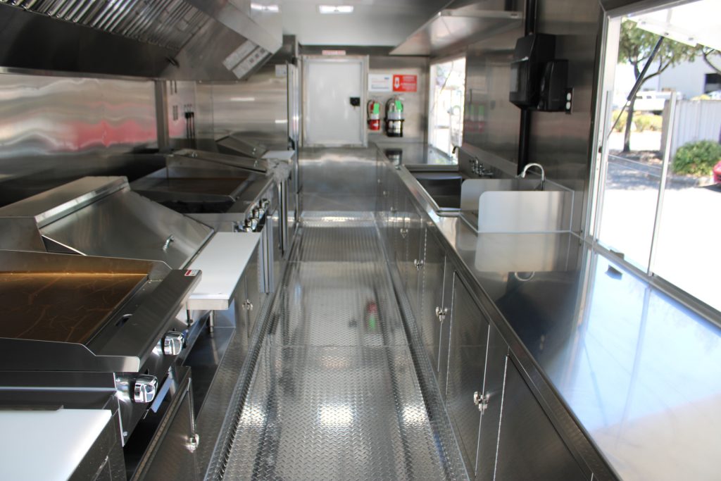 Commercial school food trailer interior with cooking line and stainless steel work areas