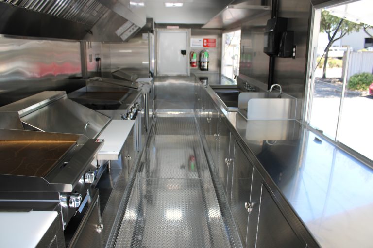 Commercial school food trailer interior with cooking line and stainless steel work areas