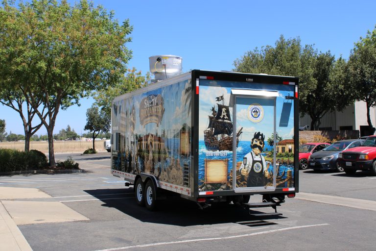 Rear exterior view of 22-ft school food trailer with custom Avenal branding