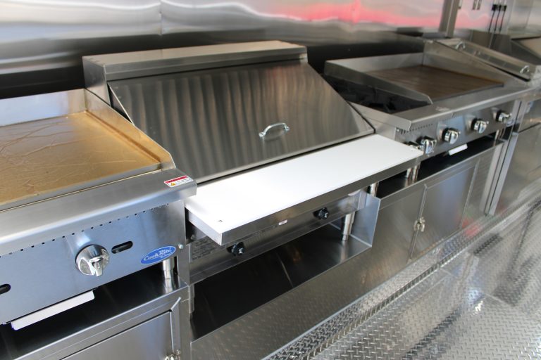 Commercial cooking equipment under hood inside The Salty Buccaneer school food trailer