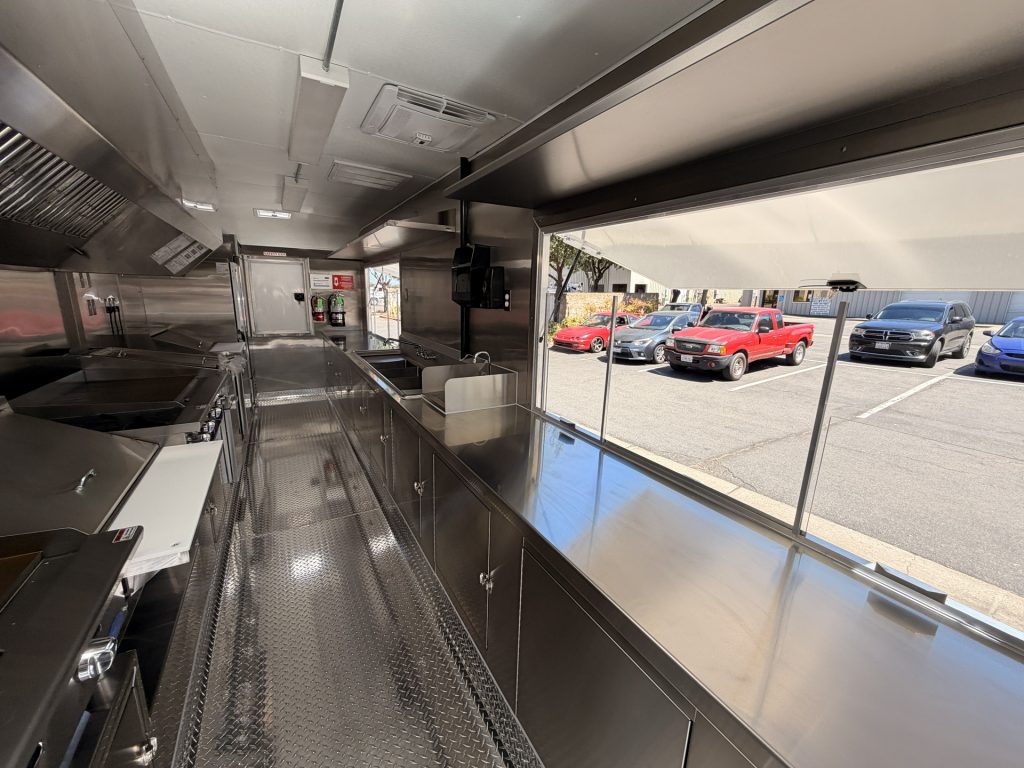 Interior of The Salty Buccaneer school food trailer with stainless steel service counters and concession window