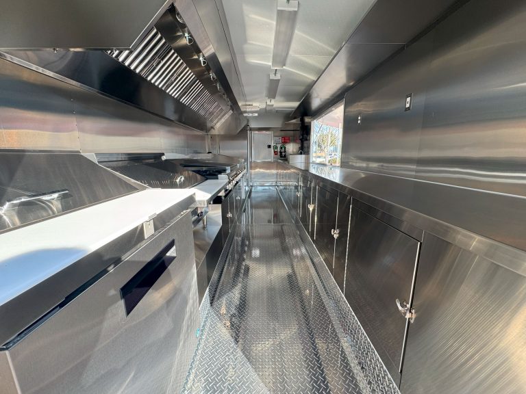 Wide interior of Cougar’s Grill 24-ft school food trailer with stainless steel commercial kitchen