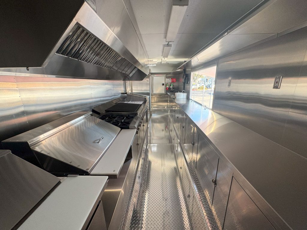 Commercial kitchen aisle inside Cougar’s Grill custom school food trailer