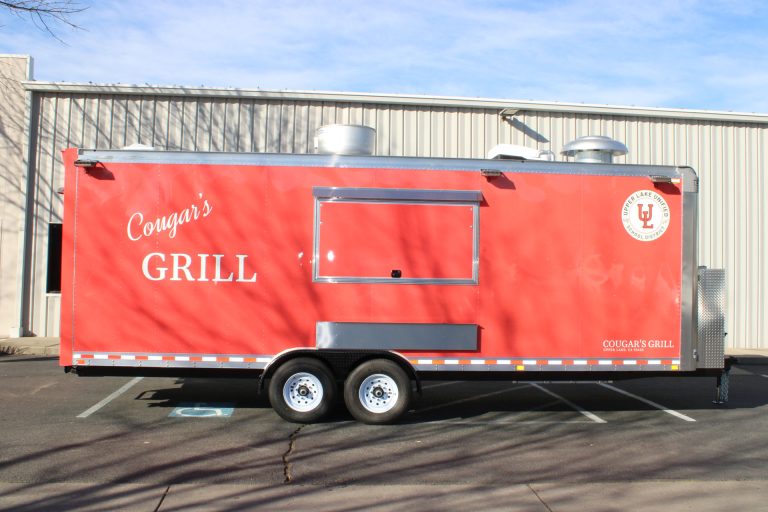 Branded side exterior of the custom Cougar’s Grill school food trailer.