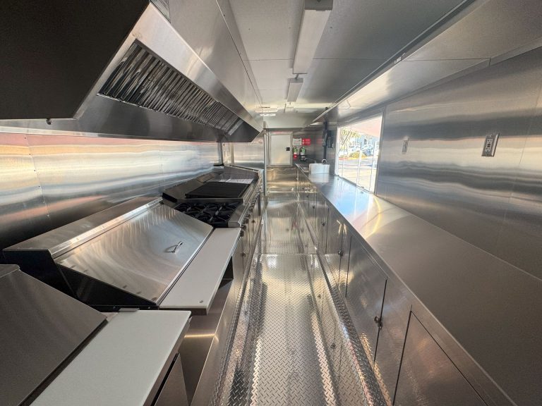Commercial kitchen aisle inside Cougar’s Grill custom school food trailer
