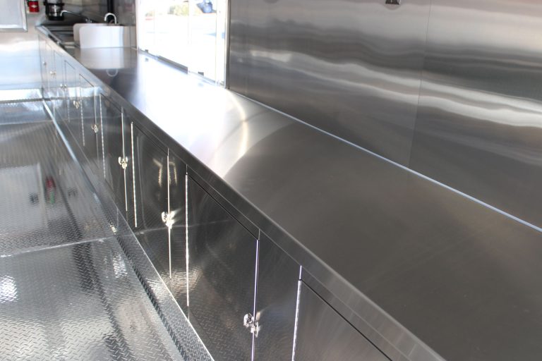 Stainless steel work counter and storage inside Cougar’s Grill school food trailer
