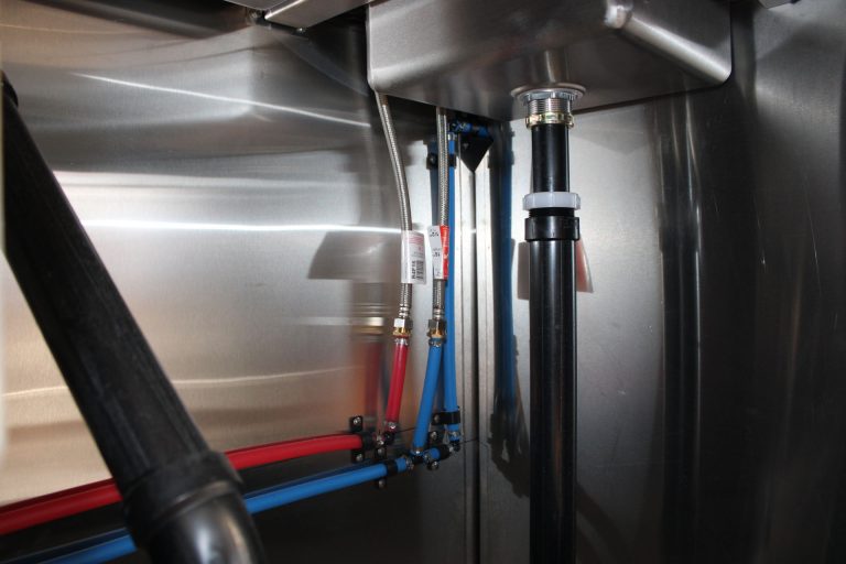 Plumbing connections inside Cougar’s Grill school food trailer