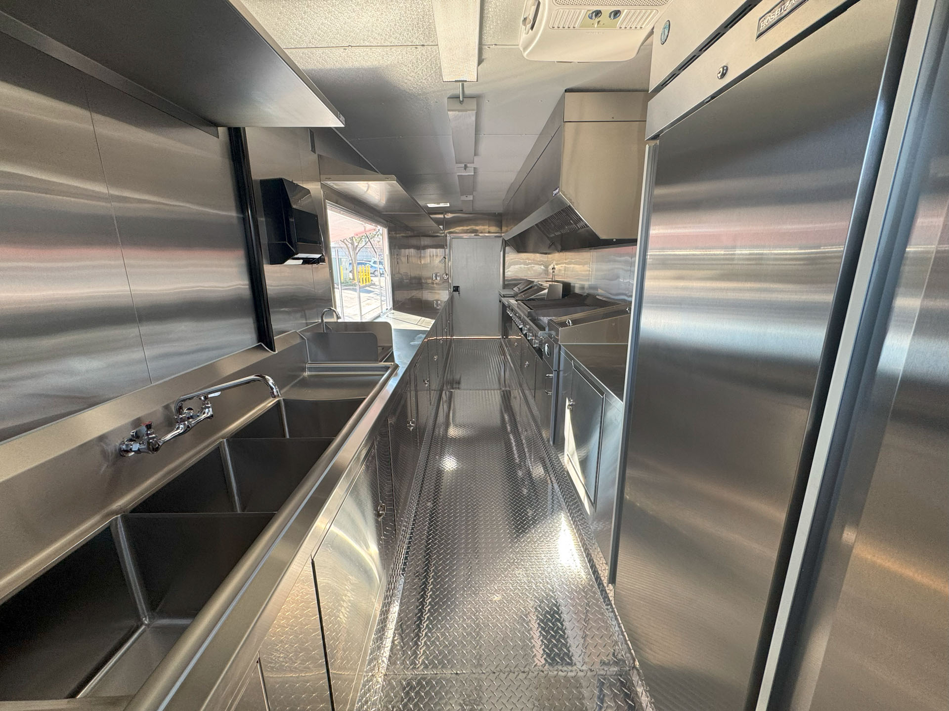 Interior of Cougar’s Grill school food trailer with stainless steel kitchen and central aisle