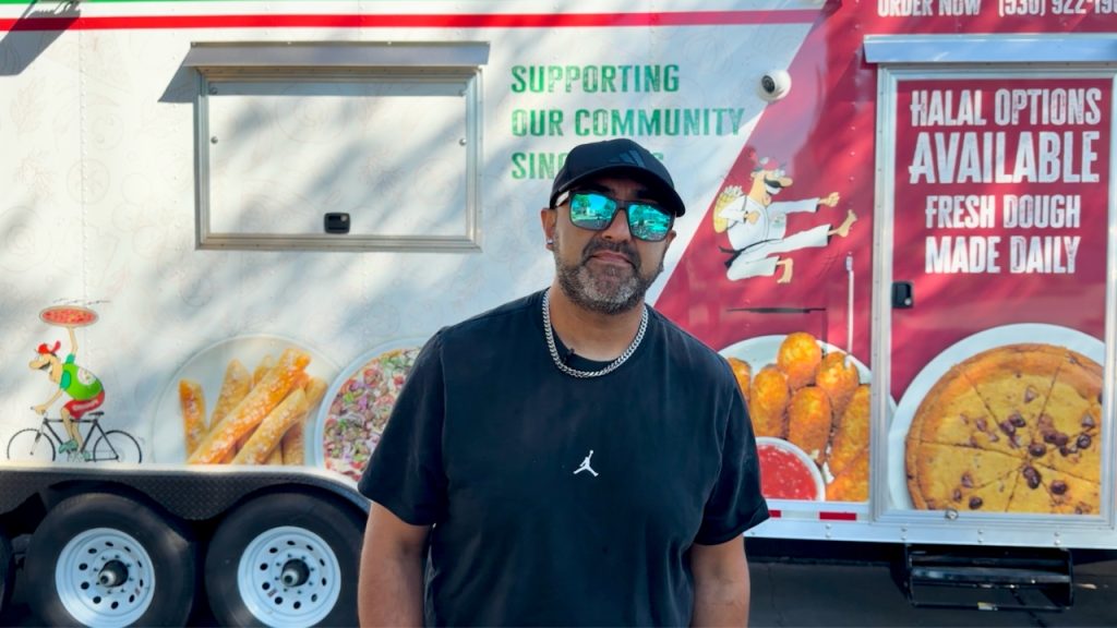 Custom pizza food trailer exterior with branded wrap and team member standing in front of the service side