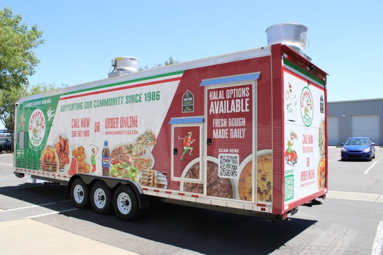 custom mobile pizza kitchen rear service-side view with wrap graphics, entry door, service windows, and triple axles