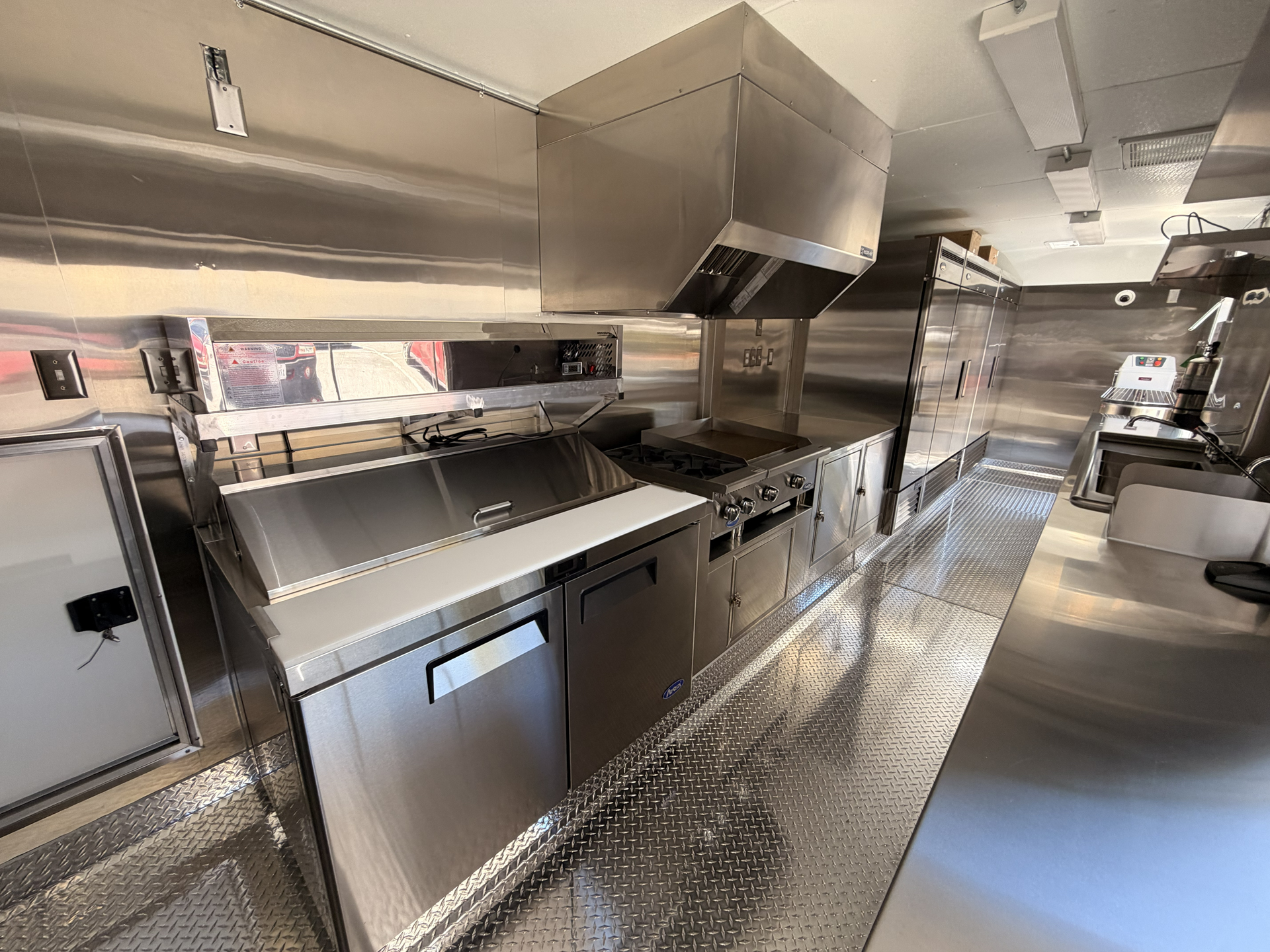 Commercial food trailer kitchen with prep, cooking, and refrigeration equipment