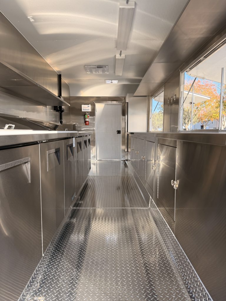 Interior aisle of 20ft training food trailer in Bonita CA with stainless steel cabinets