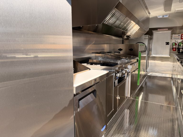 Close up cooking line inside BBQ food trailer in Gonzales CA with commercial range and hood