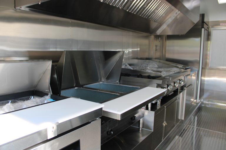Griddle and prep station under hood inside 16ft taco food trailer in Watsonville CA