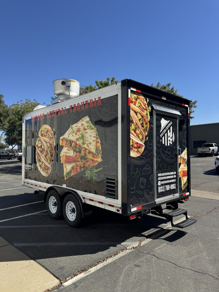 Rear view of 16ft taco food trailer in Watsonville CA with branded back door