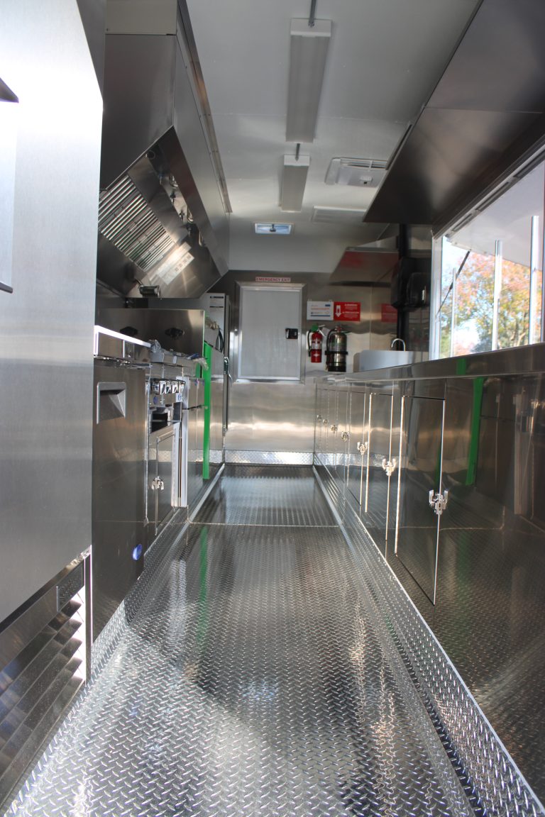 Inside BBQ food trailer in Gonzales CA with stainless steel cabinets and diamond plate flooring