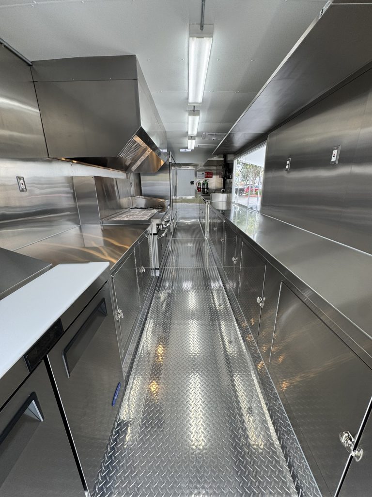 custom food trailer interior with stainless steel cabinets and diamond plate flooring