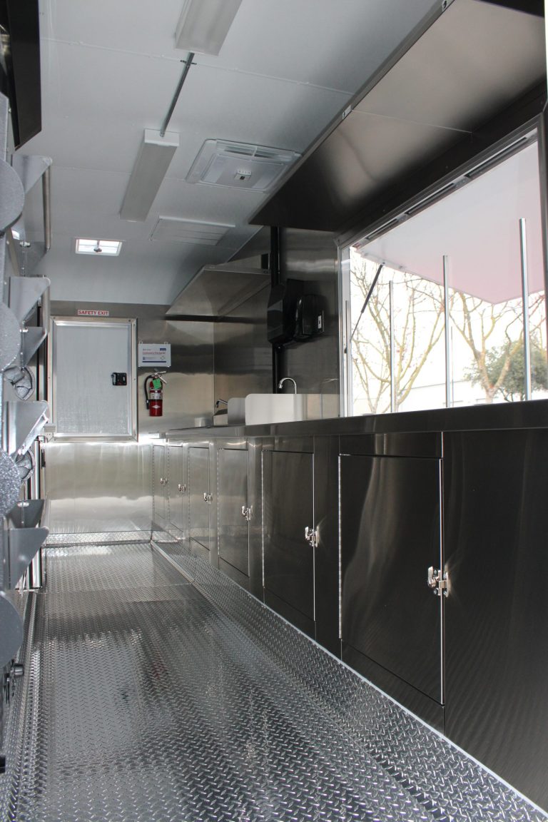 Pizza food trailer interior with stainless steel cabinets and service window