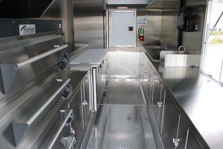 Commercial pizza trailer interior with Peerless deck ovens and prep counters