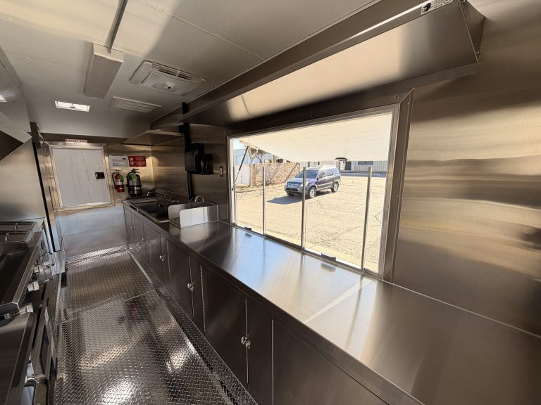 Limitless Kitchen food trailer interior with stainless steel pass-through counter, large serving window, welded cabinets and concealed electrical wiring throughout