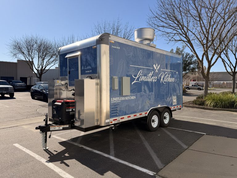 Limitless Kitchen 16ft food trailer rear side view with commercial exhaust stack, blue 3M vinyl wrap and tandem axles, custom build Golden State Trailers