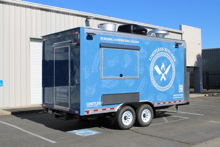 Limitless Kitchen 16ft food trailer rear three-quarter view with blue 3M wrap, rear entry door, rooftop exhaust hood and tandem axles, Golden State Trailers build