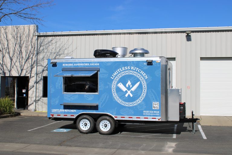 Limitless Kitchen 16ft food trailer full side view with serving window open, blue 3M wrap, commercial exhaust stack and tandem axles, Martinez California