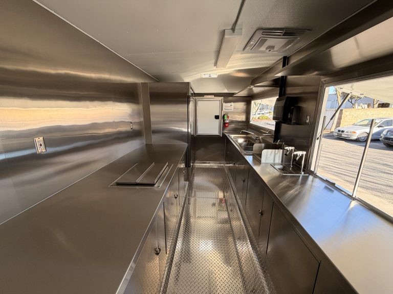 Sip'n on Sunshine lemonade trailer interior full view with stainless steel prep counters, sink station, beverage equipment and dual serving windows open