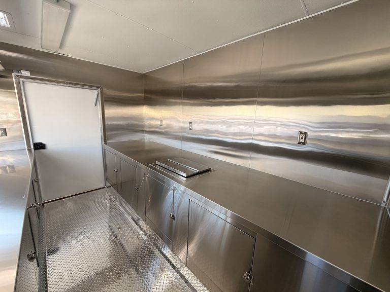 Sip'n on Sunshine lemonade trailer rear entry door and stainless steel cabinet wall with built-in equipment slot and concealed electrical outlets