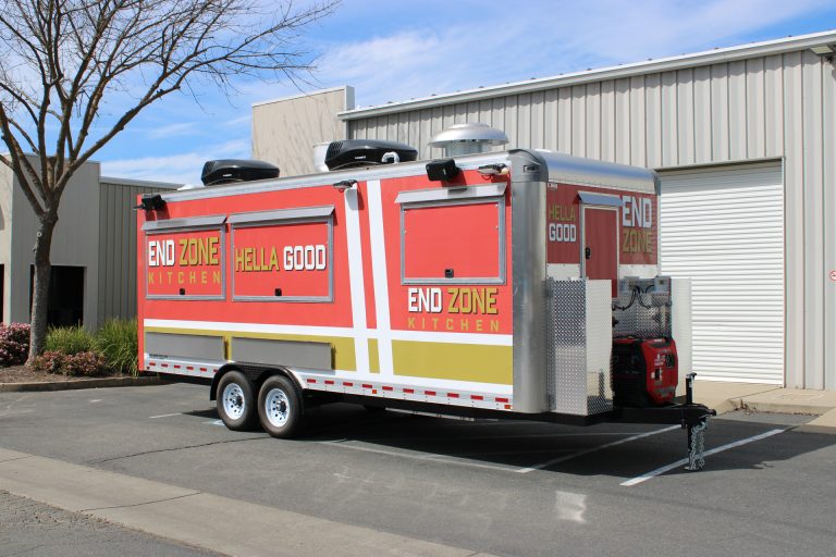 End Zone Kitchen 22ft food trailer rear side view with Hella Good branding, generator compartment, red gold 3M wrap and dual rooftop units, Santa Clara CA