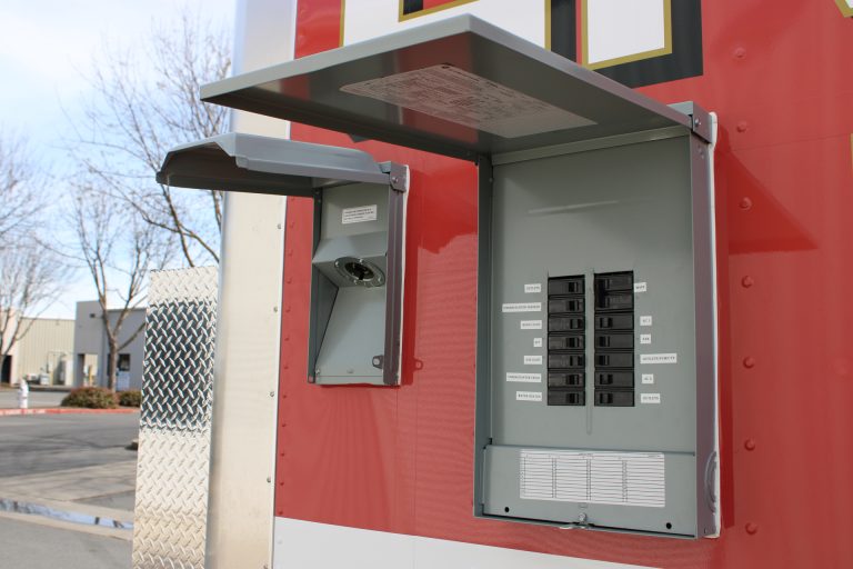End Zone Kitchen food trailer exterior electrical panel with circuit breakers and utility connection box, commercial grade electrical system by Golden State Trailers