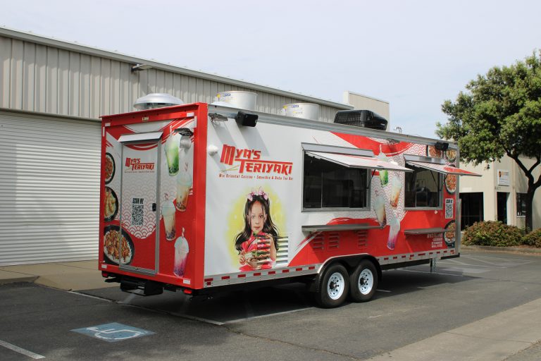 Mya's Teriyaki 24ft food trailer rear-side view with full 3M wrap branding, tandem axles and commercial rooftop equipment, Mitchell SD