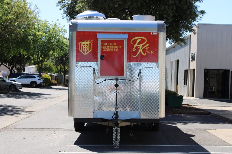 Front exterior of 18ft kettle corn trailer with aluminum storage box and rooftop ventilation