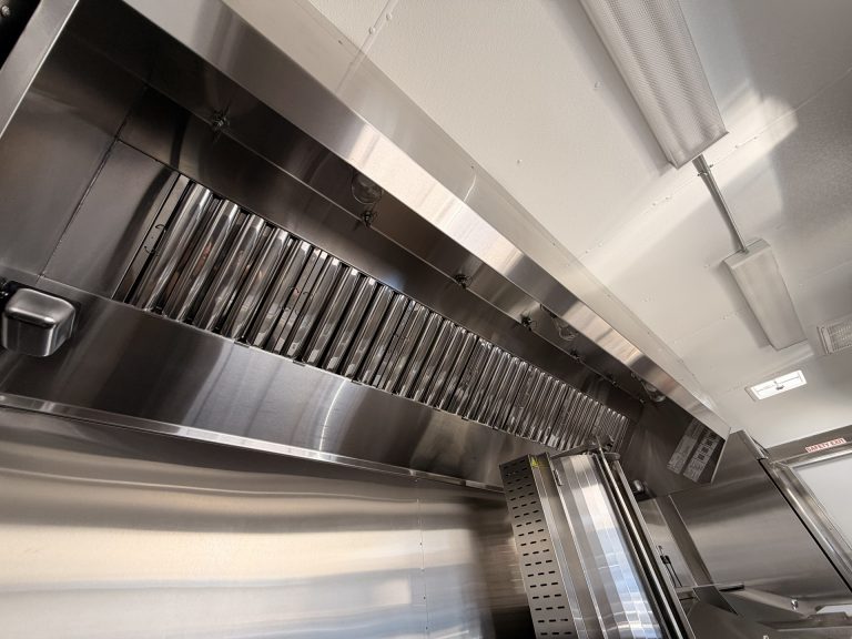 Stainless steel commercial hood ventilation system inside 16ft Mexican food trailer kitchen