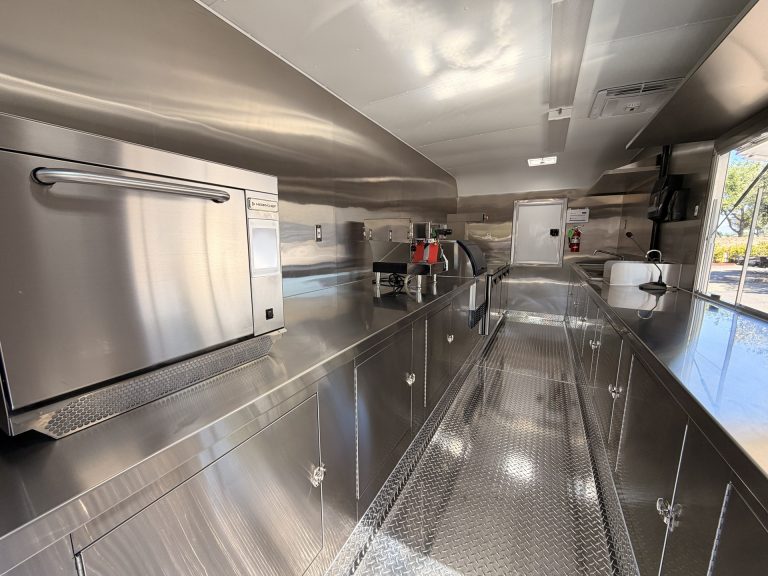Interior prep station inside 18ft American food trailer with stainless steel cabinets and countertops