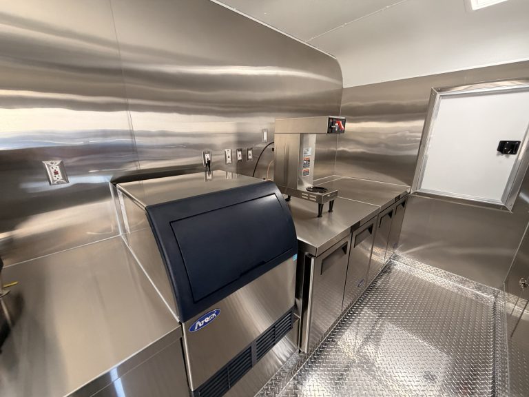 Ice machine and stainless steel prep area inside 18ft American food trailer kitchen