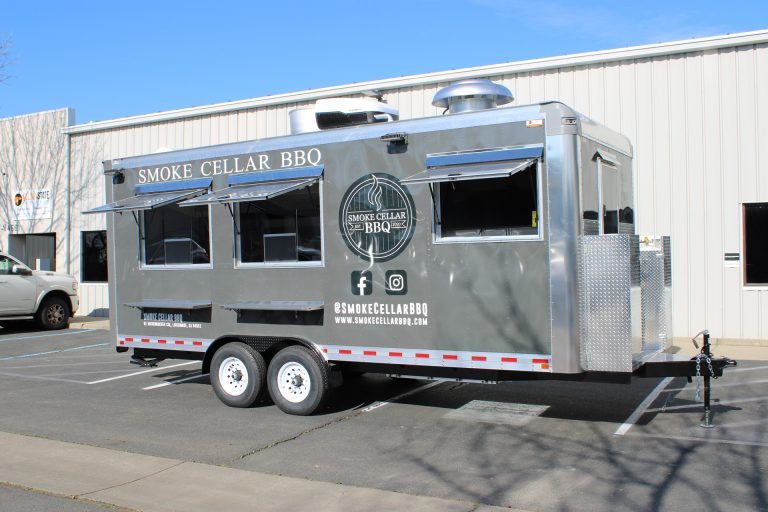 Smoke Cellar BBQ food trailer in a gray wrap with three open serving windows