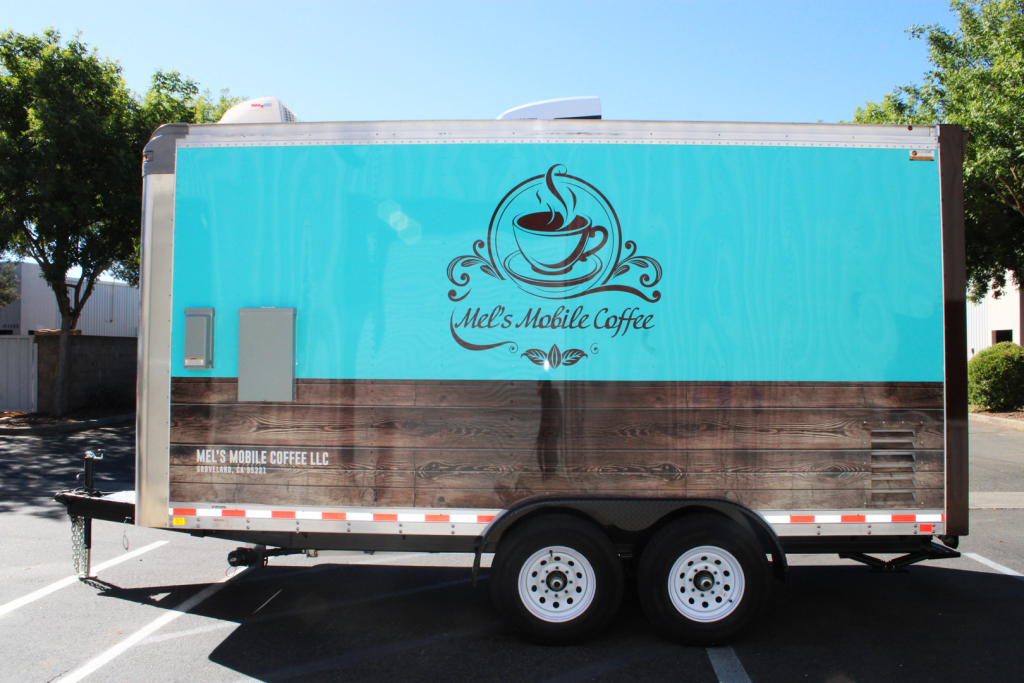 Mel’s Mobile Coffee food trailer with a teal and wood-panel wrap, a custom coffee specialist food truck design.