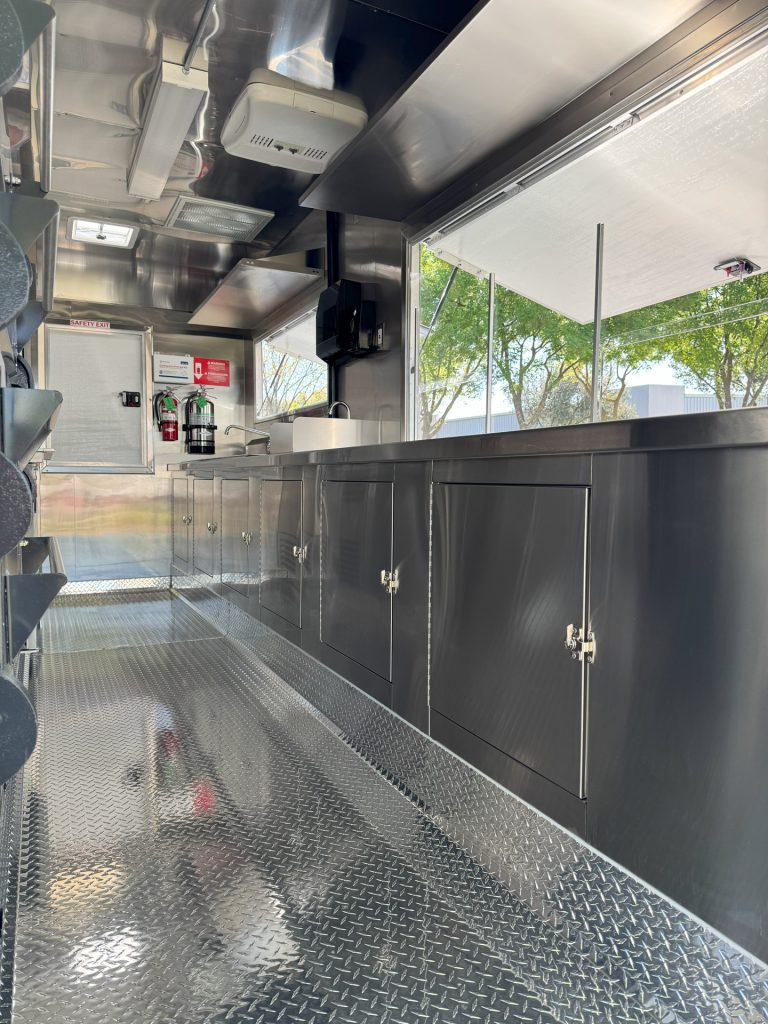 Interior stainless steel service counter inside 16ft golf course food trailer with concession window