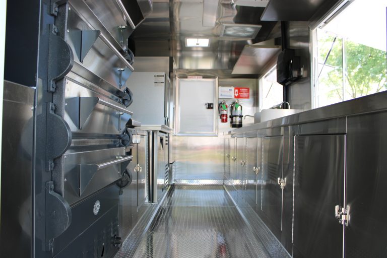 Interior kitchen aisle inside 16ft golf course food trailer with stainless steel counters and prep area