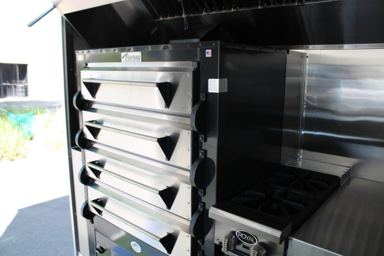 Stacked commercial pizza ovens inside 16ft golf course food trailer kitchen