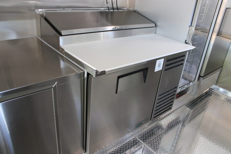 Stainless steel refrigerated prep station inside 16ft golf course food trailer kitchen