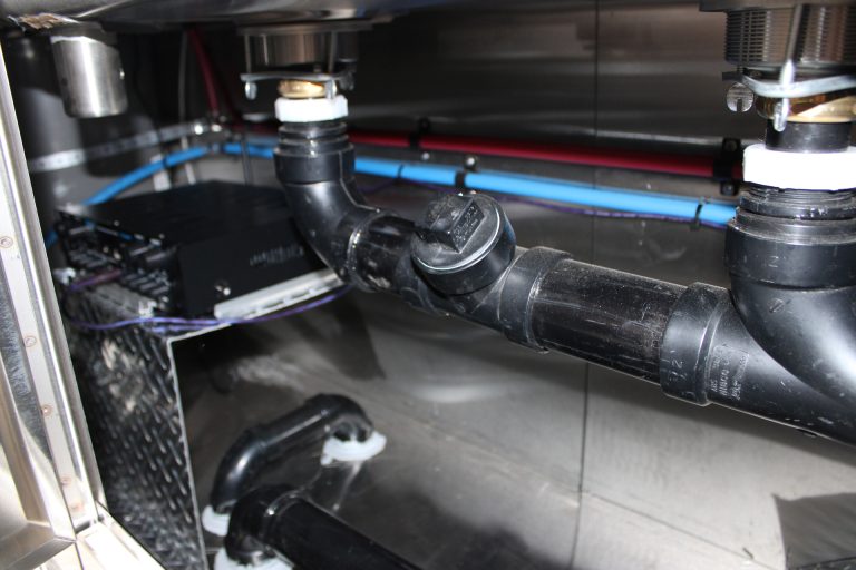 plumbing system beneath workstation in pizza food trailer
