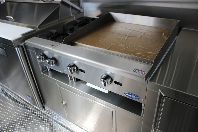 commercial flat-top griddle inside custom pizza food trailer