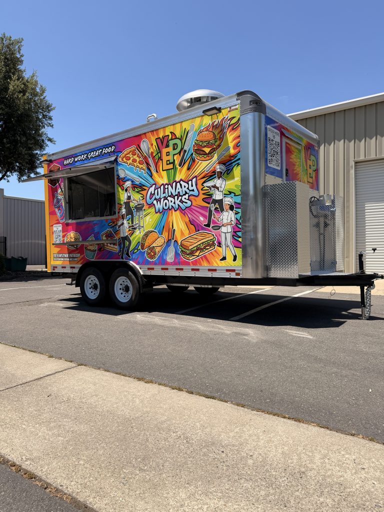 Custom Culinary Works food trailer exterior with colorful branded wrap, service window, rooftop ventilation, and tandem axle.