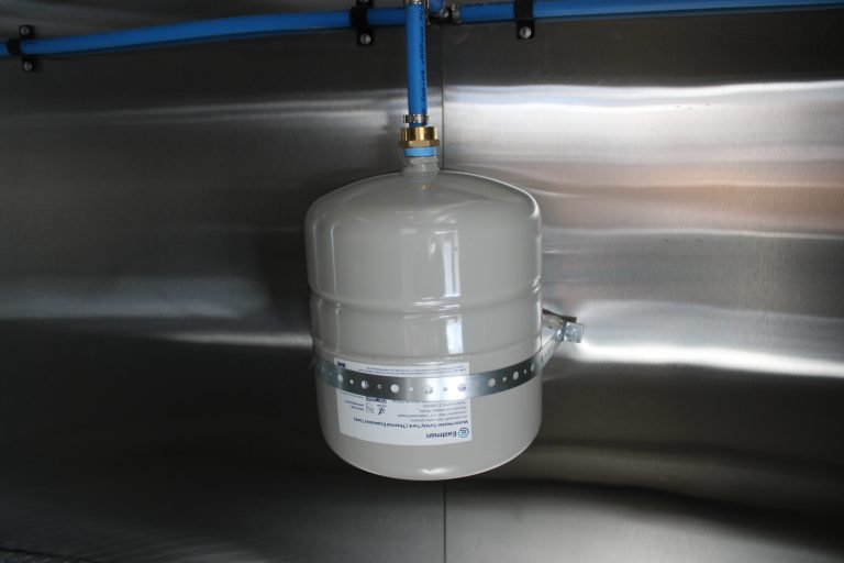 Water heater expansion tank installed in food trailer plumbing system to regulate pressure and protect the hot water system