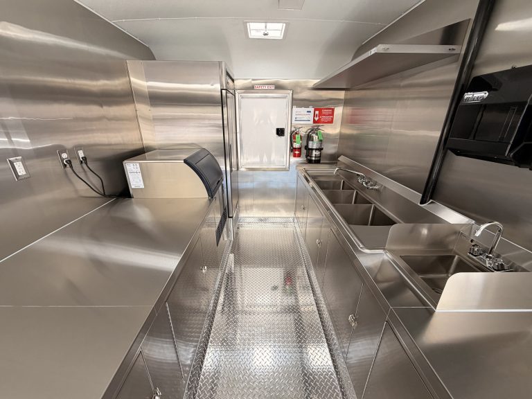 School food trailer interior with stainless steel counters, sinks, and refrigeration