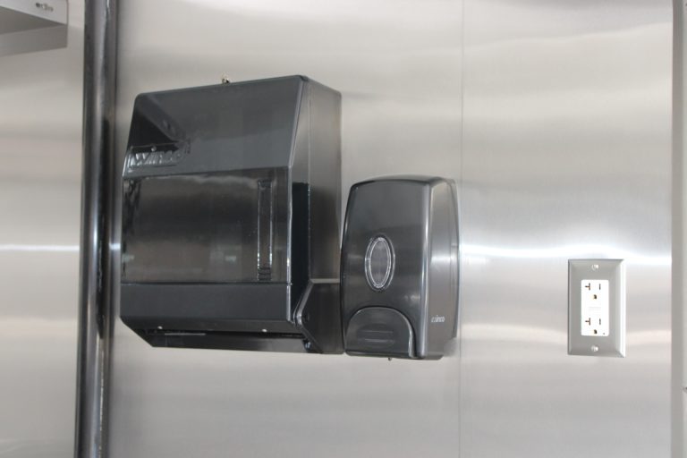 Wall-mounted dispensers in the Avenal High School school food trailer sanitation area